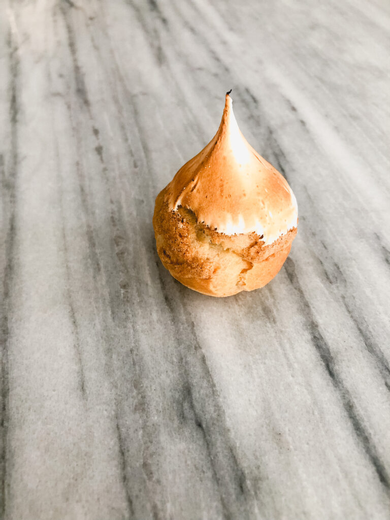Gluten Free Lemon Meringue Cream Puffs Gluten free lemon meringue cream puff on a marble table