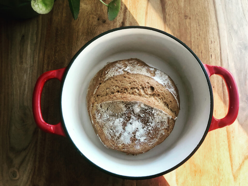 Loaf of gluten free bread in a red Dutch oven