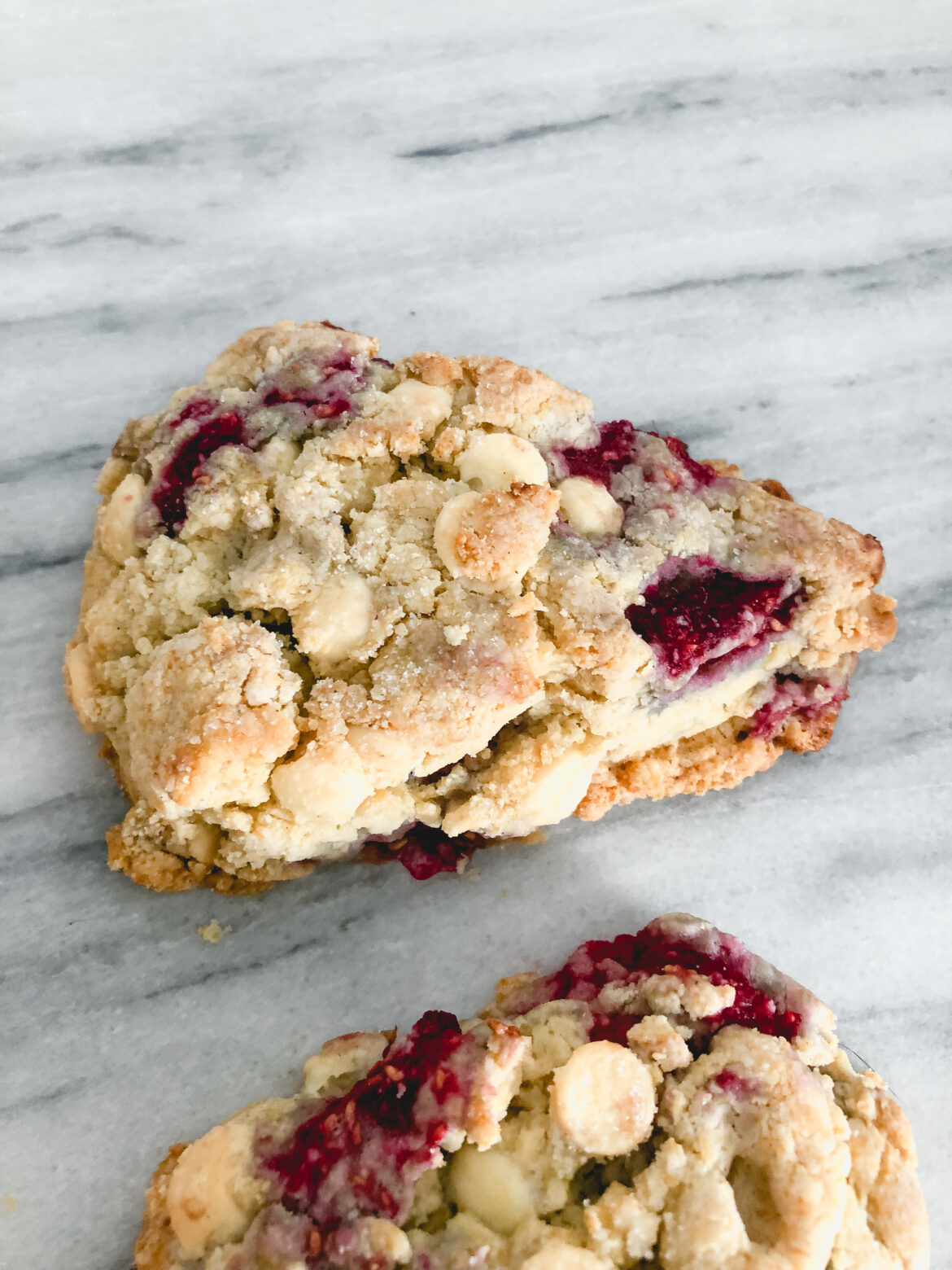 Contact Me gluten free white chocolate raspberry scone on a marble table