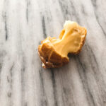 Broken open gluten free lemon meringue cream puff