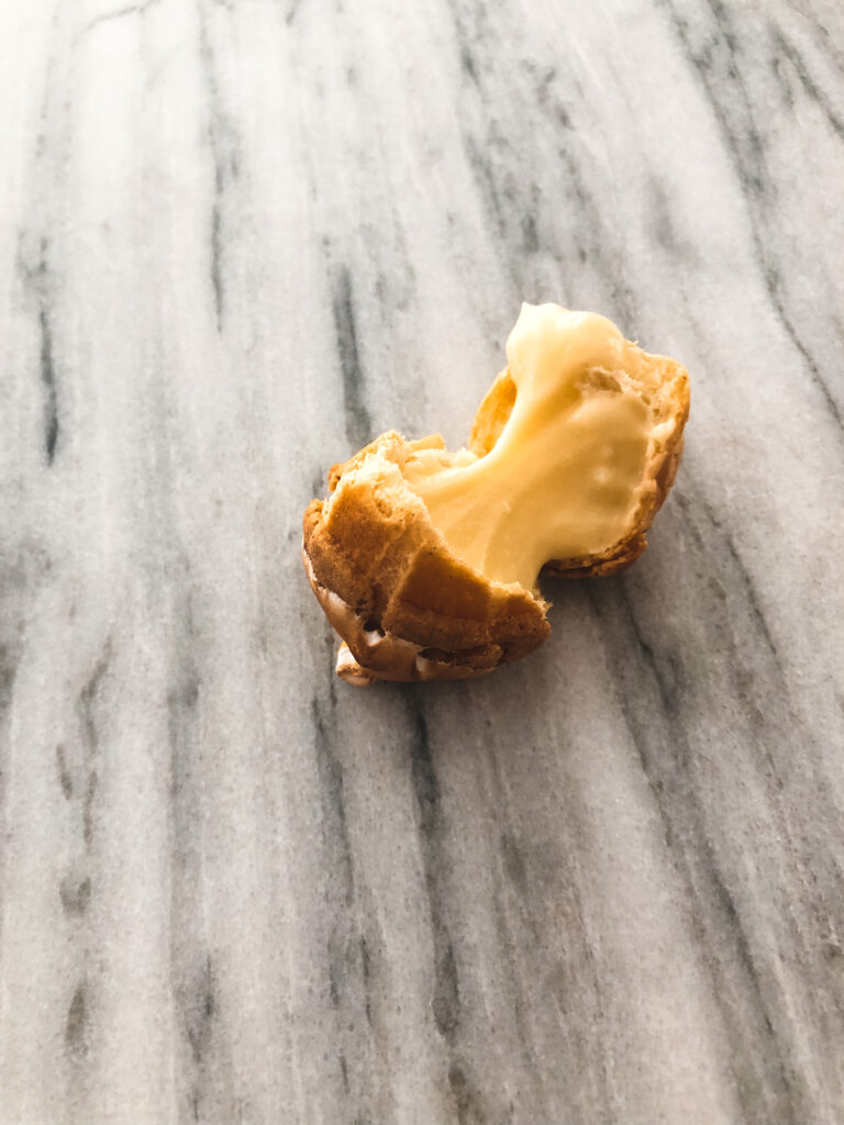 Broken open gluten free lemon meringue cream puff