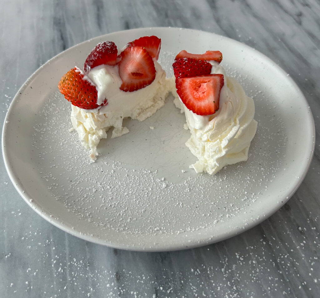 Mini Pavlova covered in strawberries and whipped cream